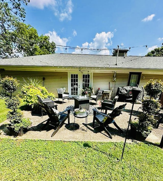 rear view of property featuring french doors, an outdoor living space, a patio, and a yard