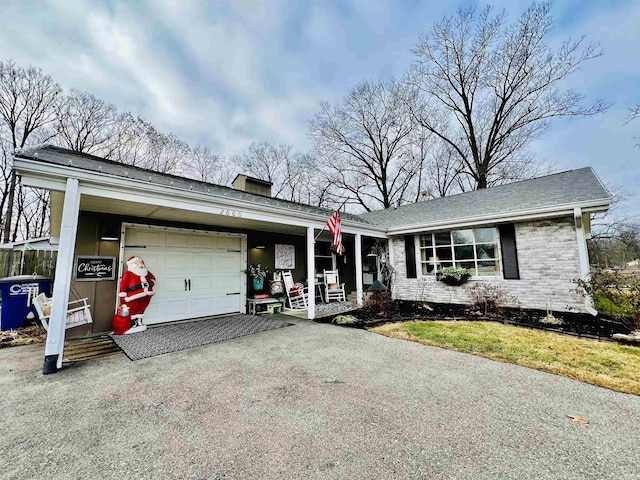 ranch-style house featuring covered porch and a garage