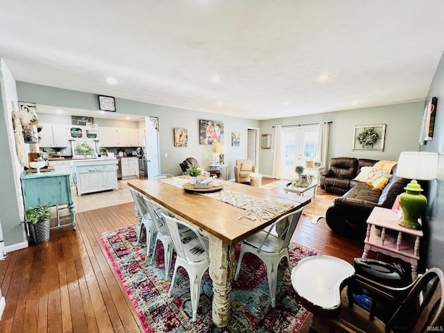 dining area with light hardwood / wood-style flooring and french doors