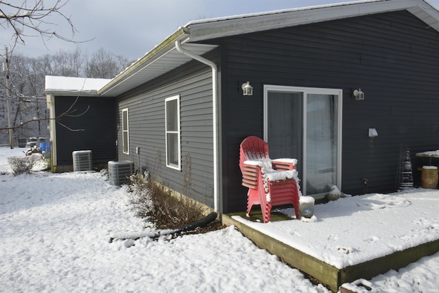 view of snow covered exterior featuring central AC unit