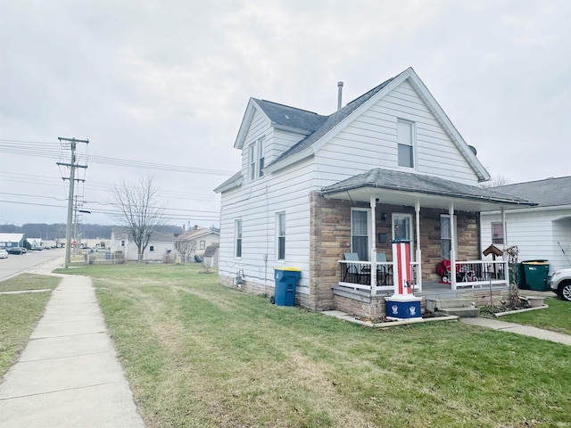 view of side of home with a lawn and covered porch