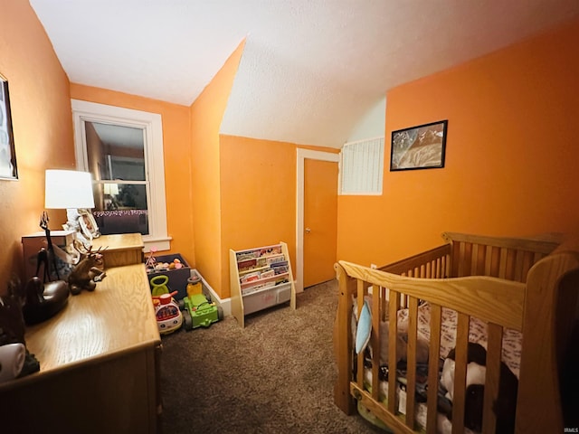 bedroom with vaulted ceiling, carpet floors, and a nursery area