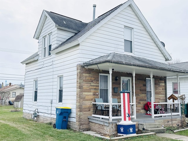 view of front of property with covered porch and a front lawn