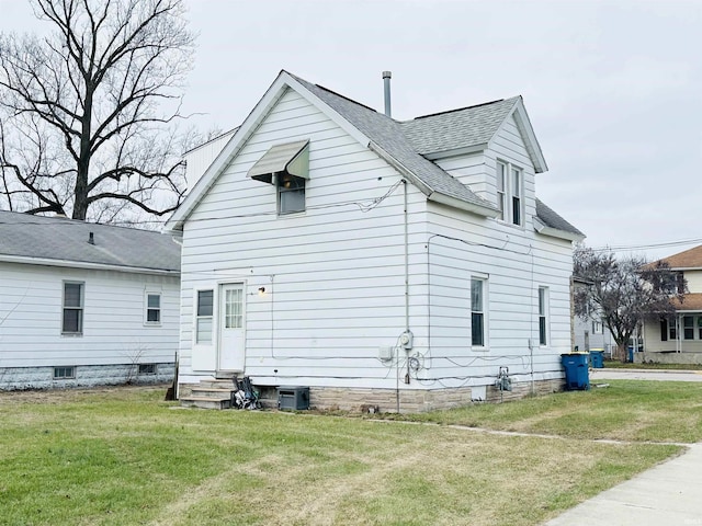 back of house with a lawn and central air condition unit