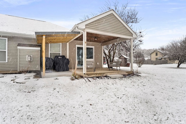 view of snow covered rear of property