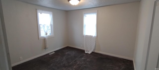 spare room with a textured ceiling