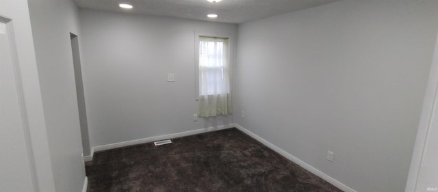 carpeted spare room featuring a textured ceiling