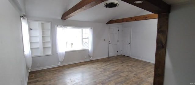 empty room with lofted ceiling with beams and wood-type flooring