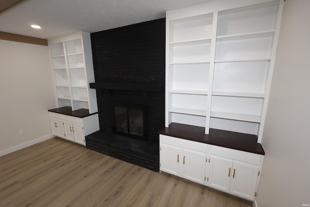 unfurnished living room with a fireplace and light hardwood / wood-style flooring