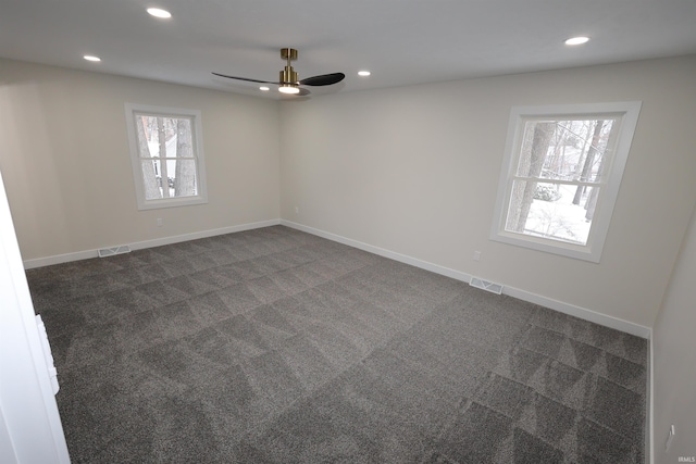 unfurnished room with dark carpet and ceiling fan