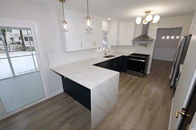 kitchen featuring wall chimney range hood, white cabinetry, a healthy amount of sunlight, and black appliances