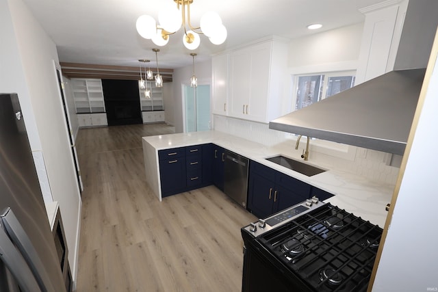 kitchen with hanging light fixtures, stainless steel dishwasher, blue cabinets, white cabinets, and light wood-type flooring