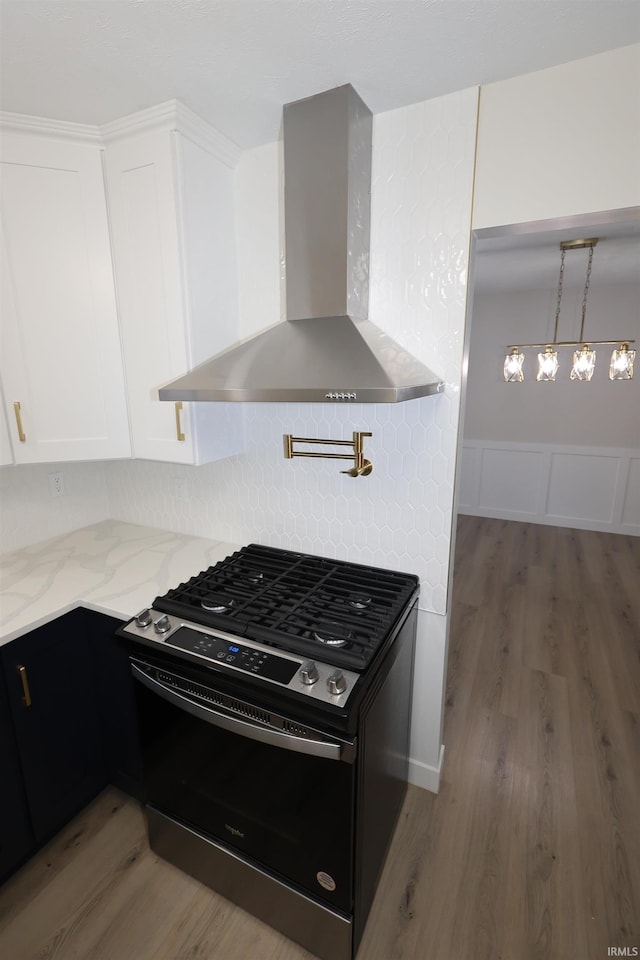 kitchen with black gas range, white cabinetry, dark hardwood / wood-style flooring, and wall chimney range hood