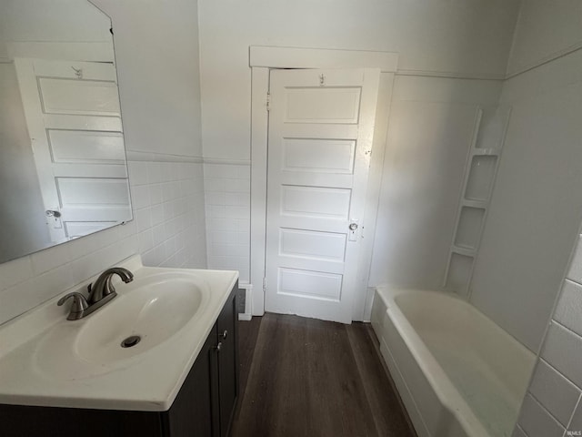 bathroom featuring vanity, hardwood / wood-style flooring, and tile walls