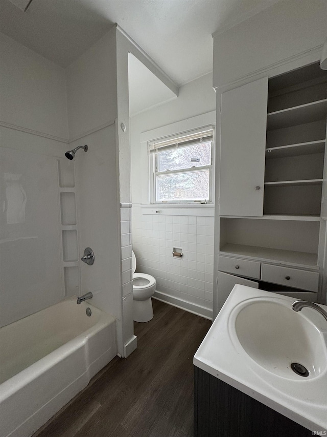 full bathroom with vanity, shower / washtub combination, toilet, tile walls, and wood-type flooring