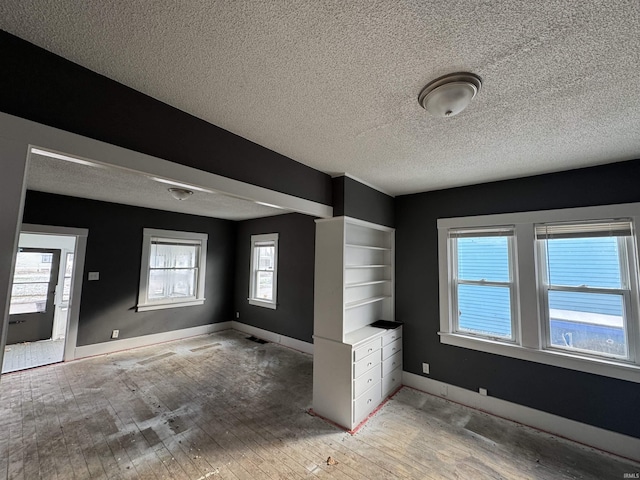 interior space with a textured ceiling and light hardwood / wood-style flooring