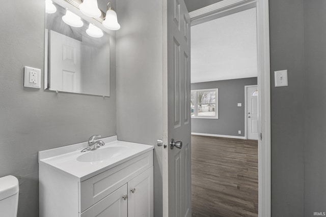 bathroom with hardwood / wood-style floors, vanity, and toilet