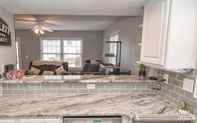 kitchen with backsplash, white cabinetry, ceiling fan, and a textured ceiling