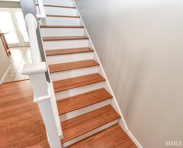 staircase with hardwood / wood-style floors