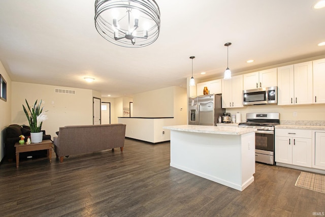 kitchen featuring pendant lighting, dark hardwood / wood-style floors, white cabinets, and appliances with stainless steel finishes