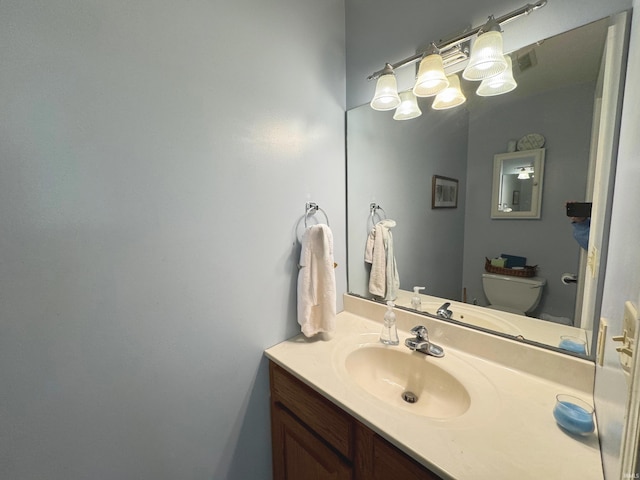 bathroom featuring vanity and toilet