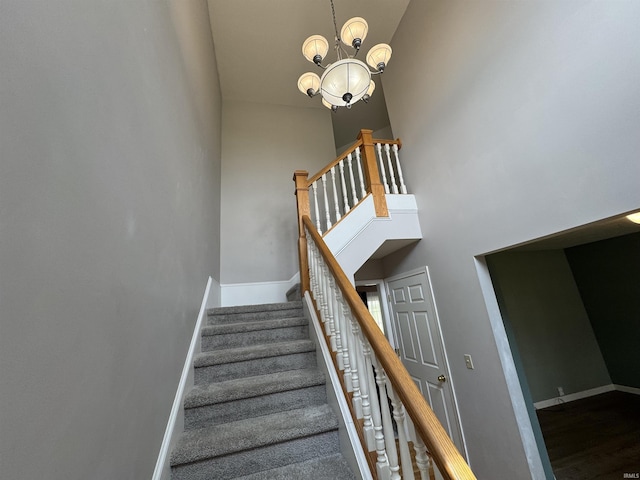 2609 S Isabel Ct, Bloomington, IN 47403 - staircase featuring baseboards, a high ceiling, a chandelier, and wood finished floors
