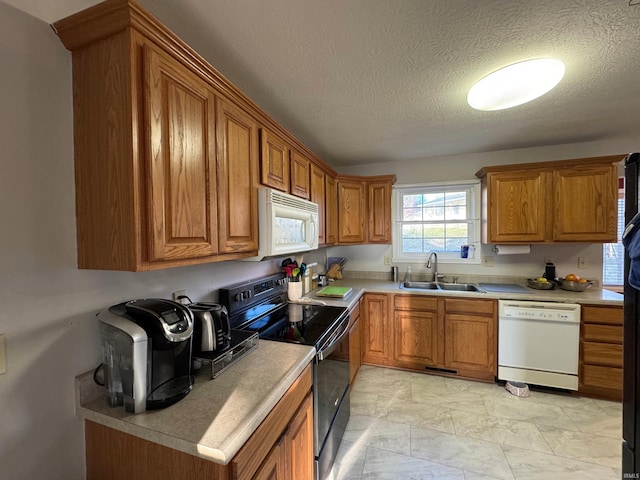 kitchen with white appliances, sink, and a textured ceiling