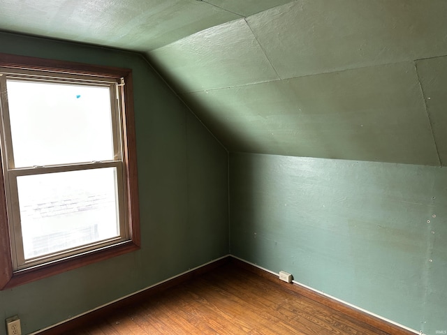 additional living space with dark hardwood / wood-style floors and vaulted ceiling