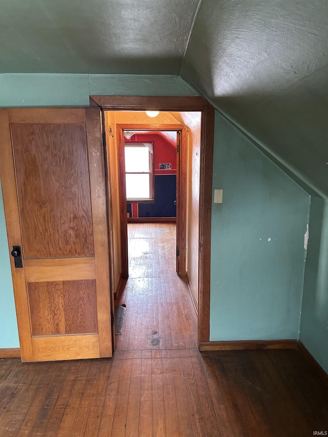 additional living space with dark hardwood / wood-style floors, a textured ceiling, and vaulted ceiling