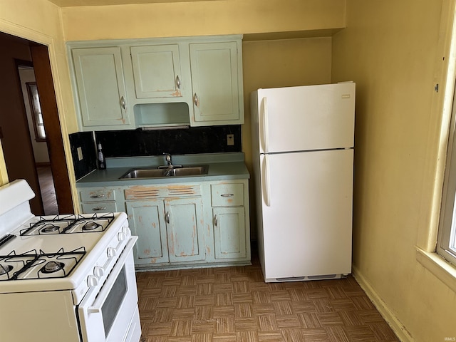 kitchen with parquet flooring, decorative backsplash, white appliances, and sink