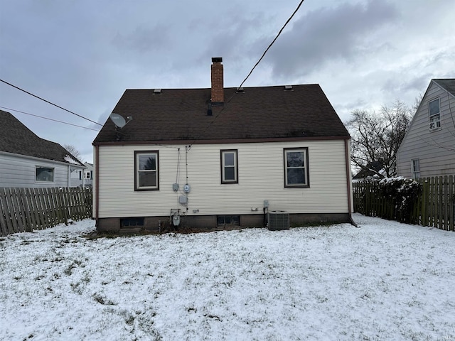 snow covered property with central AC unit