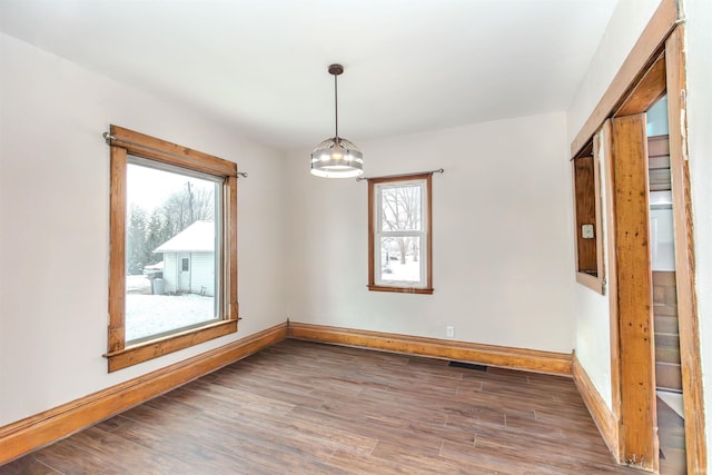 spare room with dark hardwood / wood-style flooring and a notable chandelier