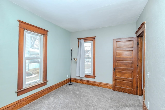 carpeted empty room featuring a wealth of natural light