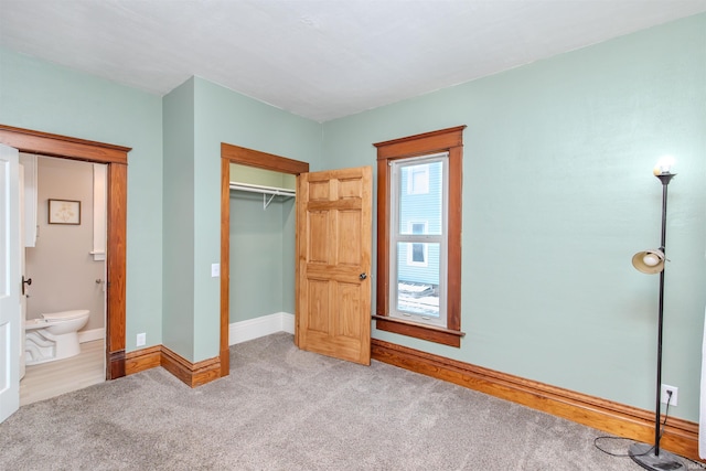 unfurnished bedroom with light carpet and a closet