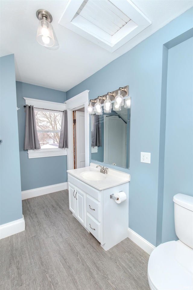 bathroom with hardwood / wood-style floors, vanity, and toilet