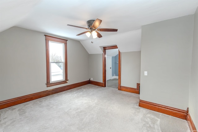 additional living space with light colored carpet, vaulted ceiling, and ceiling fan