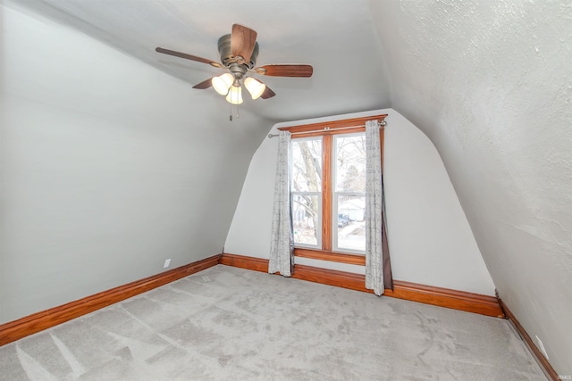 bonus room with a textured ceiling, ceiling fan, lofted ceiling, and light carpet