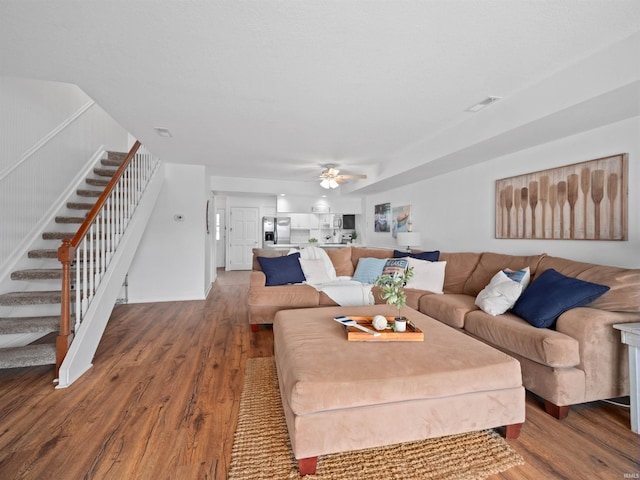 living room featuring hardwood / wood-style floors and ceiling fan