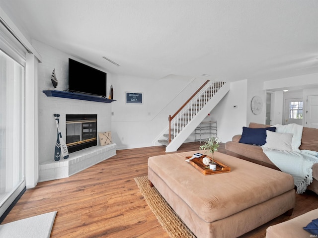 living room featuring light hardwood / wood-style floors and a brick fireplace