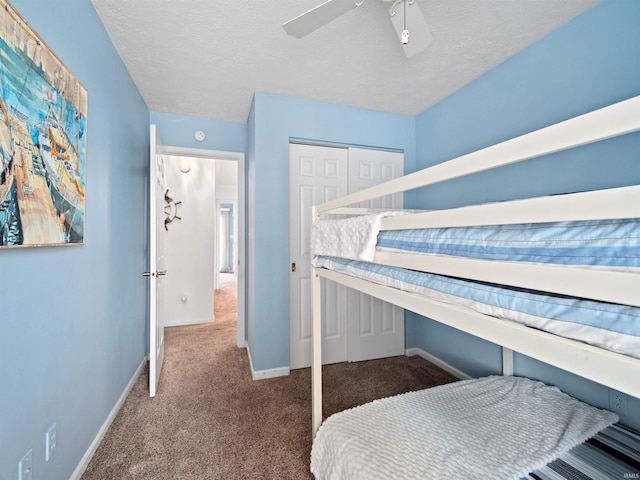 carpeted bedroom featuring ceiling fan, a closet, and a textured ceiling