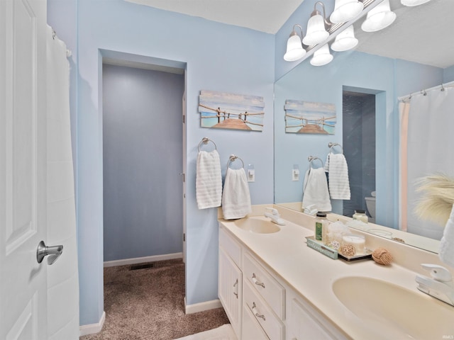 bathroom featuring a shower with curtain, vanity, and toilet