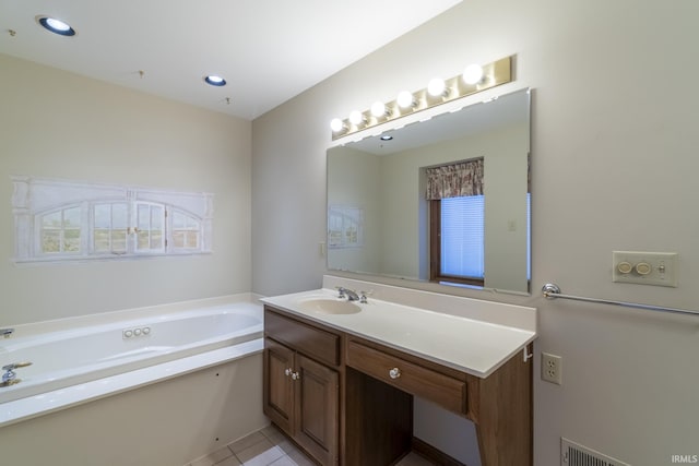 bathroom featuring a bathing tub, vanity, and tile patterned flooring