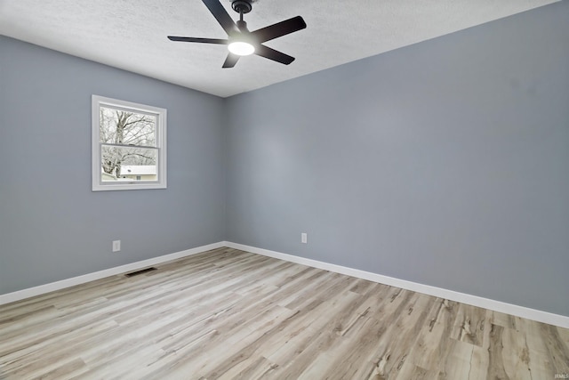 unfurnished room with ceiling fan, light hardwood / wood-style flooring, and a textured ceiling