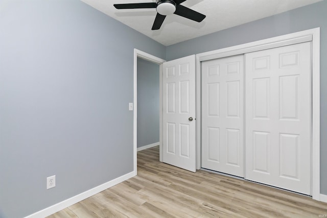 unfurnished bedroom featuring light wood-type flooring, a closet, and ceiling fan