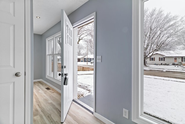 doorway featuring light hardwood / wood-style floors and a textured ceiling