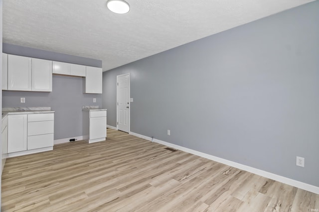 interior space featuring a textured ceiling and light hardwood / wood-style floors