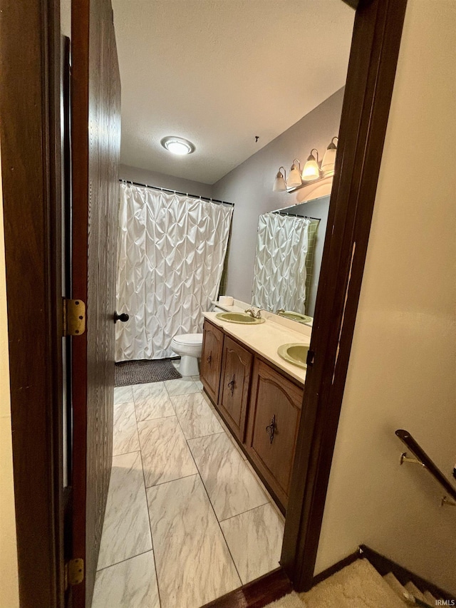 bathroom with a shower with shower curtain, vanity, and toilet