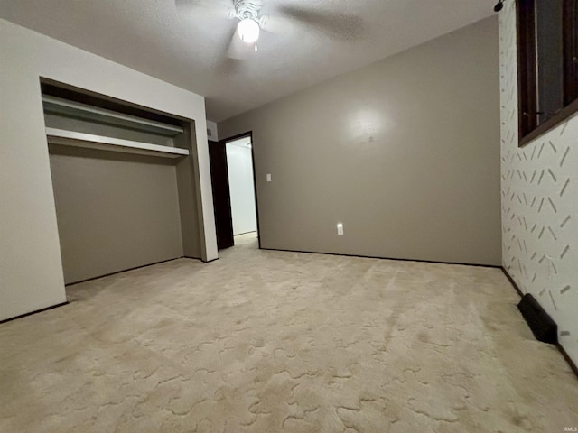 unfurnished bedroom featuring light carpet, a closet, and ceiling fan