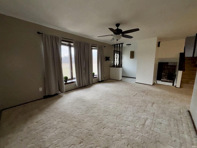 unfurnished living room featuring ceiling fan and light colored carpet