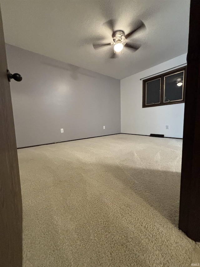 carpeted spare room with ceiling fan and a textured ceiling